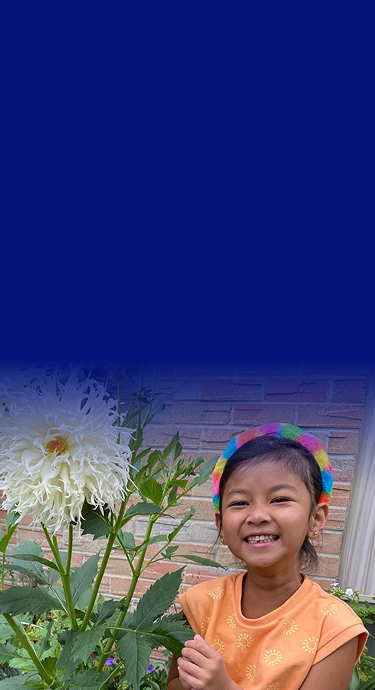 Thea smiling next to a flower