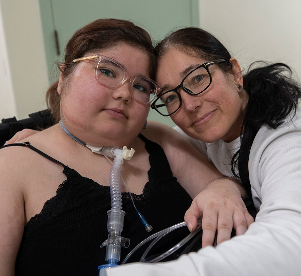 Tanika at SickKids, sitting with her mother beside her, both looking at the camera.