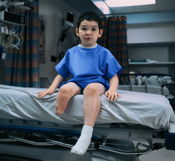 Jasper at SickKids, sitting on a hospital bed
