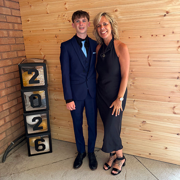 Mason Donkin and his mother, Jennifer, pose for a photo wearing formal attire.
